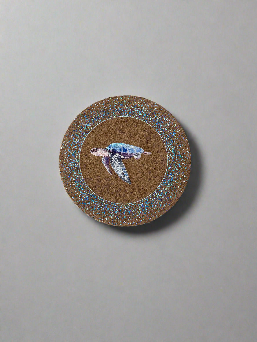 Round coaster with sea turtle design on a textured surface